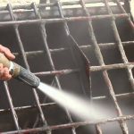 Image of a metal concrete grate being blasted